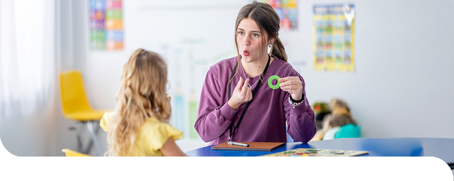 Eine angehende Erzieherin &uuml;bt mit einem Kind die Aussprache und unterst&uuml;tzt die sprachliche Entwicklung.