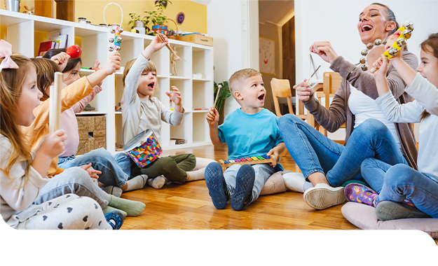 Eine Erzieherin musiziert mit einer Kindergruppe und sorgt f&uuml;r Freude, Bewegung und gemeinsames Lernen.