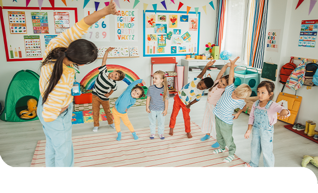 Eine Erzieherin leitet eine Bewegungs&uuml;bung an und motiviert die Kinder zu Spiel und k&ouml;rperlicher Aktivit&auml;t.