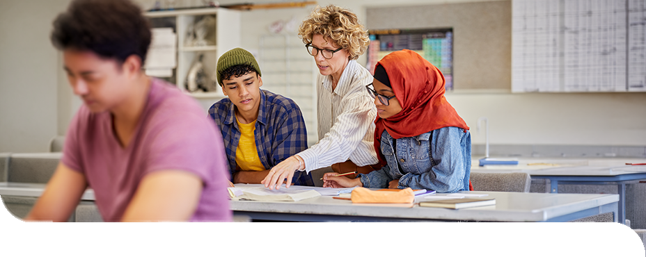 Eine Lehrkraft unterst&uuml;tzt Jugendliche im Unterricht, erkl&auml;rt Inhalte pers&ouml;nlich und f&ouml;rdert individuelles Lernen im Klassenverband.