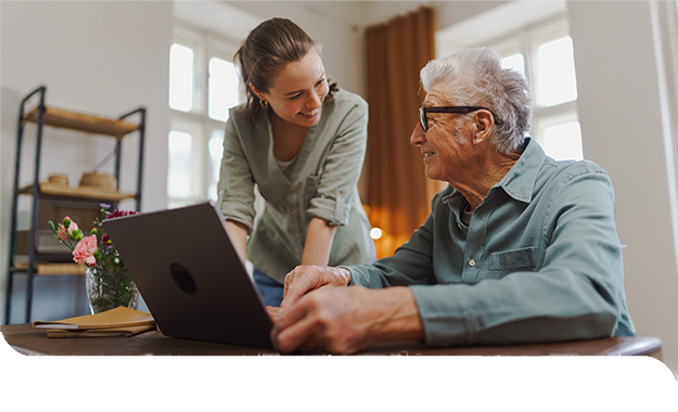 Eine Fachkraft erkl&auml;rt einer Seniorin den Umgang mit einem Laptop und begleitet sie geduldig beim Erlernen neuer digitaler F&auml;higkeiten.